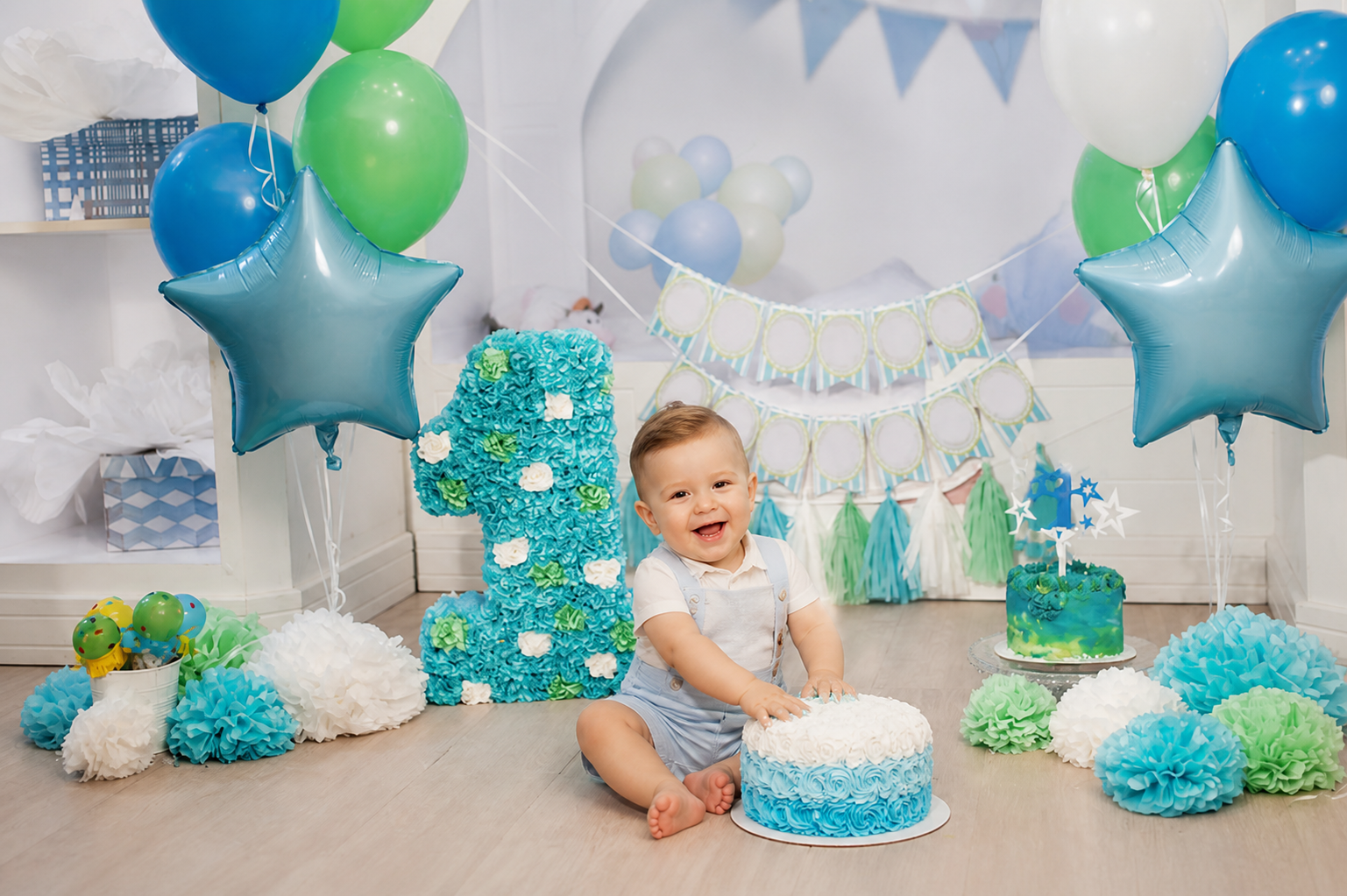 One-year-old boy cake smash scene with blue and green balloon first birthday backdrop